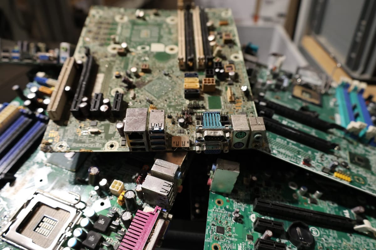 Discarded circuit boards and cables sorted into crates at an electronics recycling drop-off